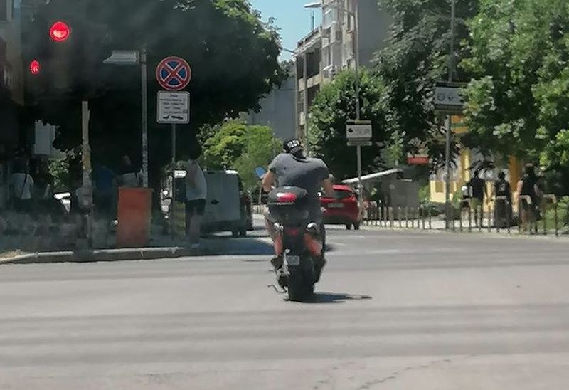 Хем говори по телефона, хем кара без каска, хем минава на червено...
