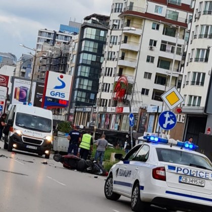 Моторист лежи на асфалта след инцидент, линейка е на място