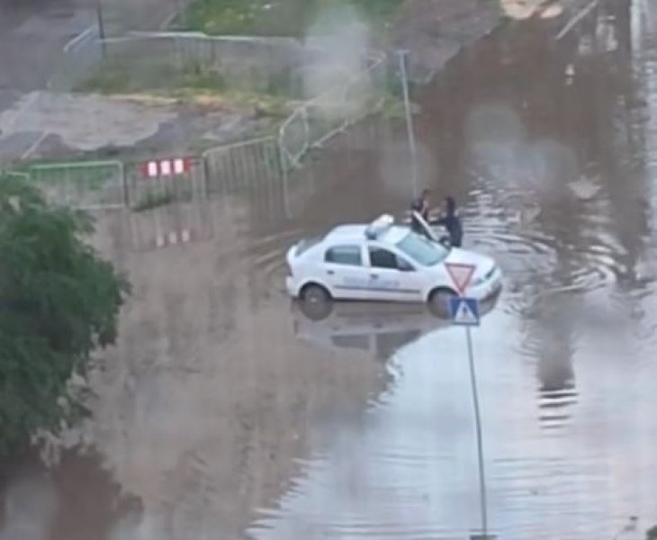 Патрулка закъса на наводнена улица, полицаите слязоха да бутат СНИМКИ