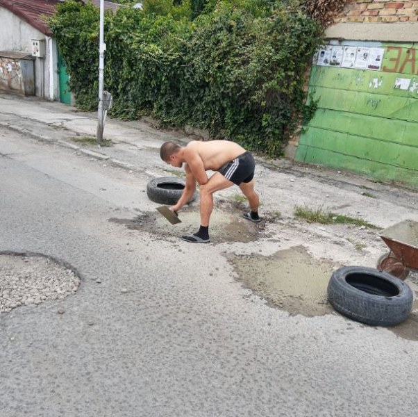 Млади мъже запретнаха ръкави - пълнят дупките по разбита улица СНИМКИ