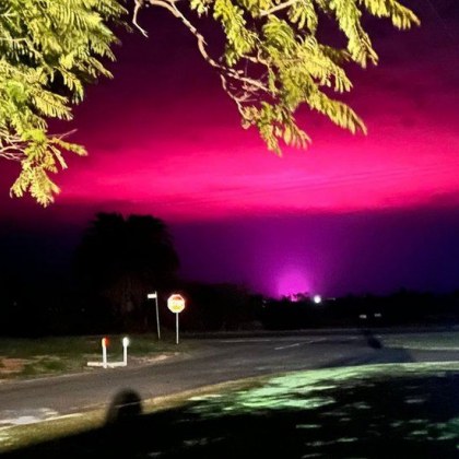 Когато розово сияние осветява вечерното небе над австралийски град в