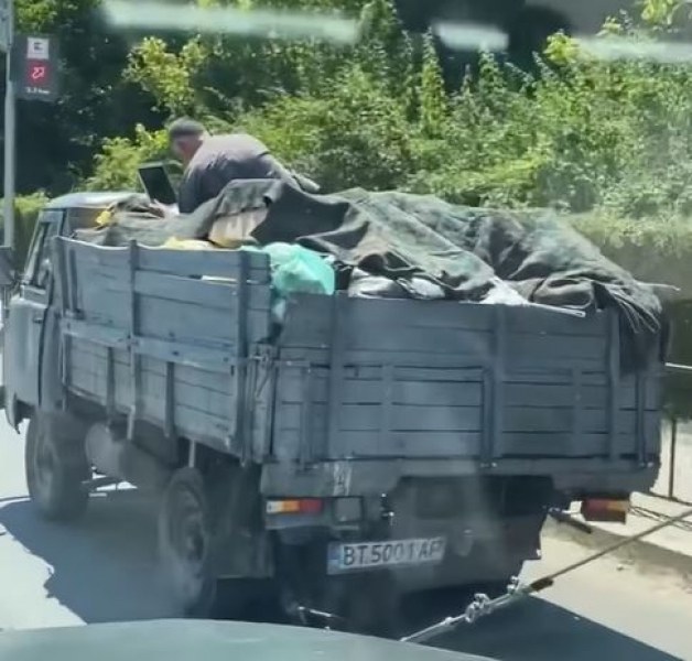 Мъж се вози в каросерията на камион, докато ползва лаптопа си ВИДЕО