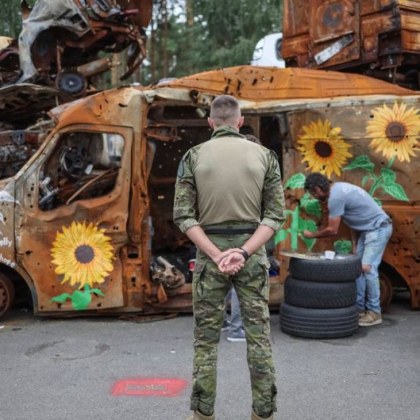 Художници рисуват слънчогледи по останките от изгорели коли в Ирпин
