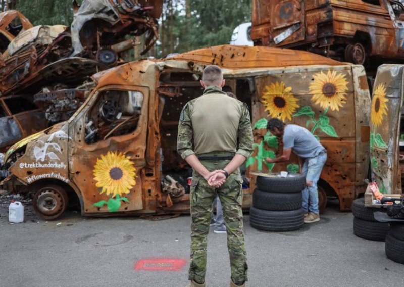 Художници рисуват слънчогледи по останките от изгорели коли в Ирпин,