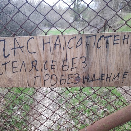 Табела поставена на ограда на имот изуми с посланието си