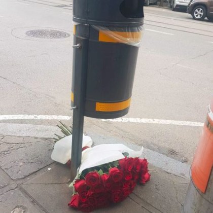Снимка на красив букет рози захвърлен до кофа за боклук