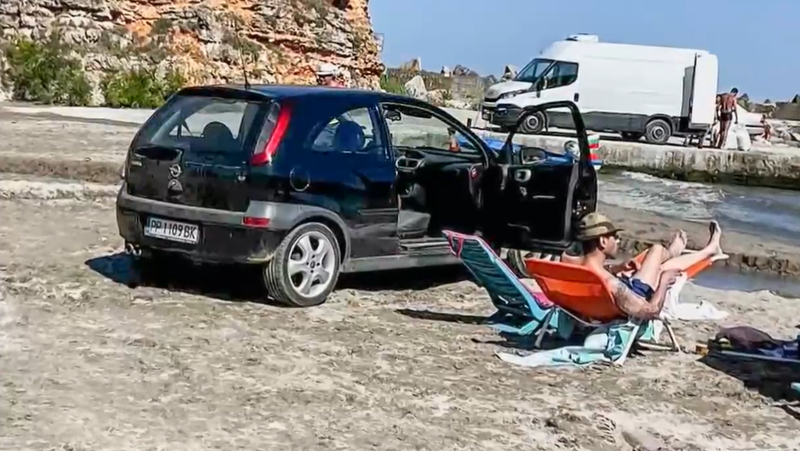 Пореден случай на паркиран автомобил на пясъчна ивица край морето.