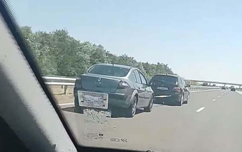 Два леки автомобила са заснети да се теглят на автомагистрала.
