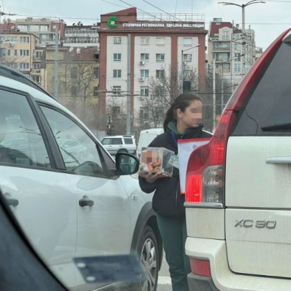 Момиче с кутия за дарения обикаля сред колите в София