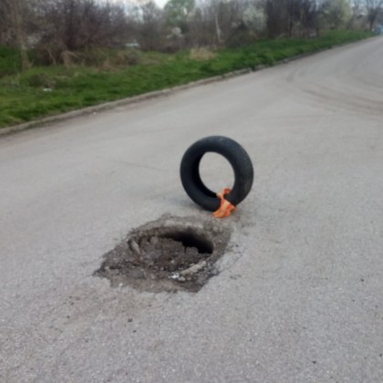 Автомобилна гума сигнализира за дълбока дупка на улица в Дмимитровград