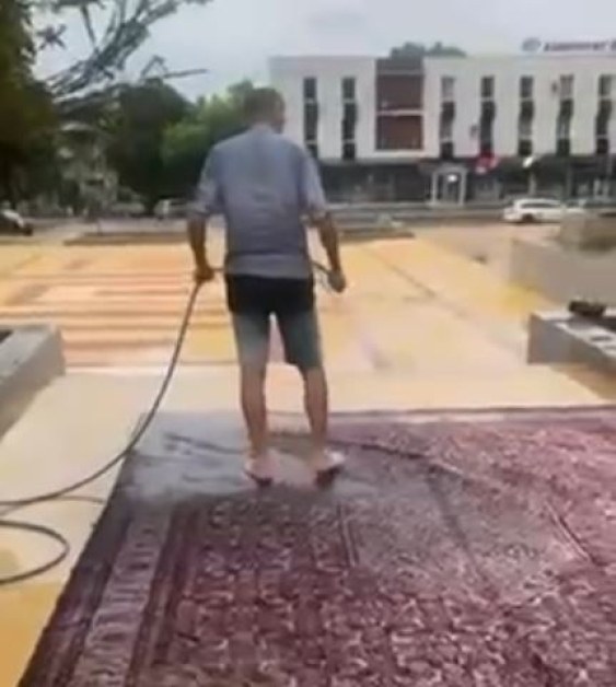 Абсурд? Мъж пере килим на централния площад в Сопот ВИДЕО