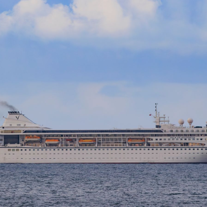 Американски круизен кораб пътуващ за околосветско пътешествие отплава край бреговете