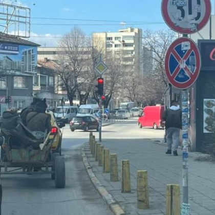 Хора с каруца търпеливо чакат на червен светофар за да