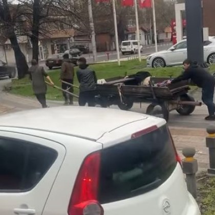 Кючек трафик и група деца които теглят каруца по тротоар