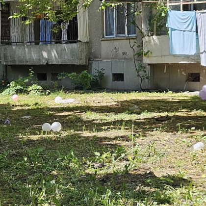 Разпилени балони от празнична украса останали край жилищен блок в