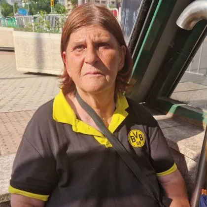 Седнала е на стълбите пред метростанция Витоша сгушена в сянката