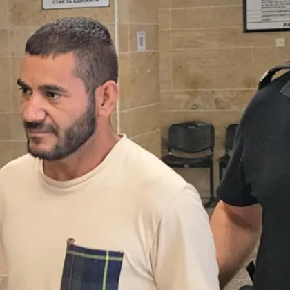 Под засилен полицейски конвой и окован с белезници на ръцете