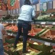 Жена стъпка с обувки зеленчуци в супермаркет, за да стигне до висок рафт СНИМКА