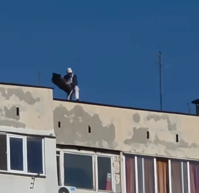 Опасна практика: Работници хвърлят боклуци от покрива на жилищен блок