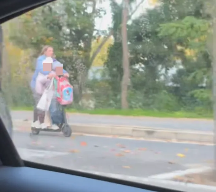 Майка вози двете си деца на електрическа тротинетка