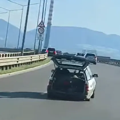 Шофьор е сниман да кара с отворен багажник който е