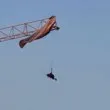 Парапланерист висна от висок кран ВИДЕО