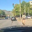 Жена подкара тротинетка по улица, дете се държи за крака ѝ СНИМКА