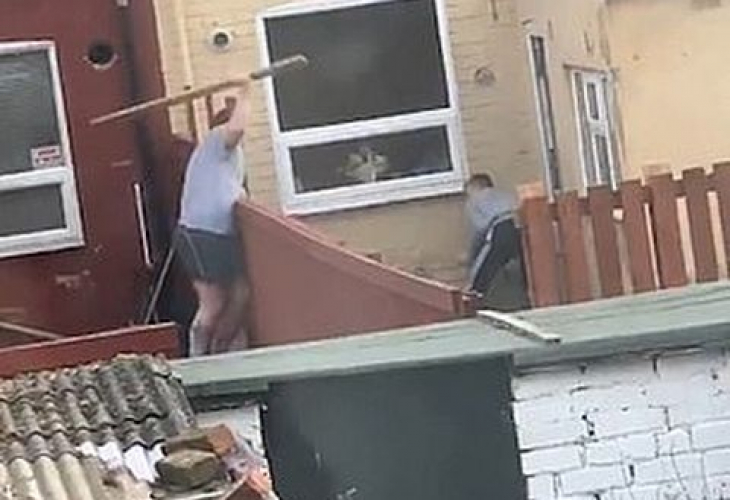 Комшии се млатят брутално с дъски през оградата (ВИДЕО)